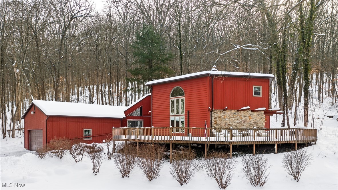 Rear view of property with a wooden deck and a garage
