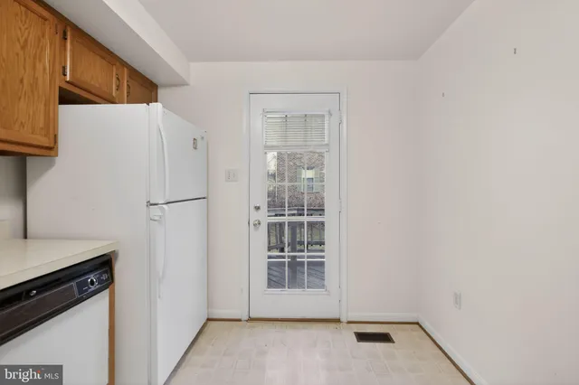 a view of a kitchen with white cabinets and a refrigerator