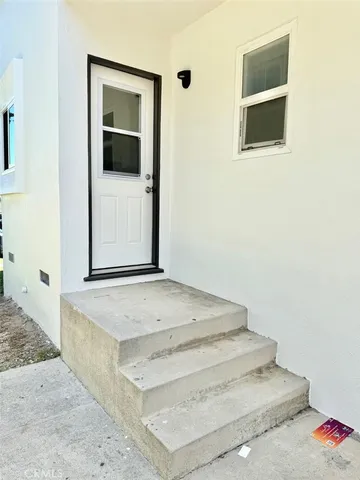 a view of a hallway with wooden floor and cabinet
