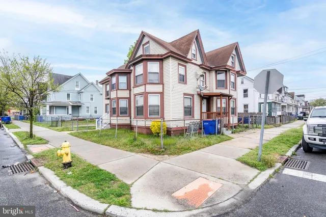 a view of a big yard in front of a brick house