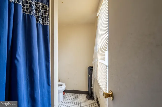 a bathroom with a toilet and a shower curtain