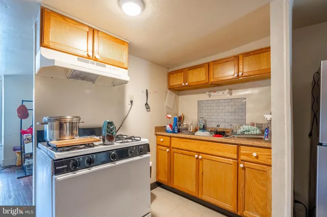 a kitchen with stainless steel appliances granite countertop a sink and a stove next to a window