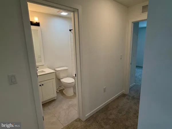 a bathroom with a granite countertop toilet a sink and a mirror