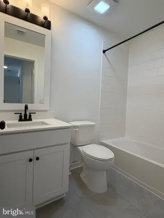 a bathroom with a sink mirror vanity and toilet