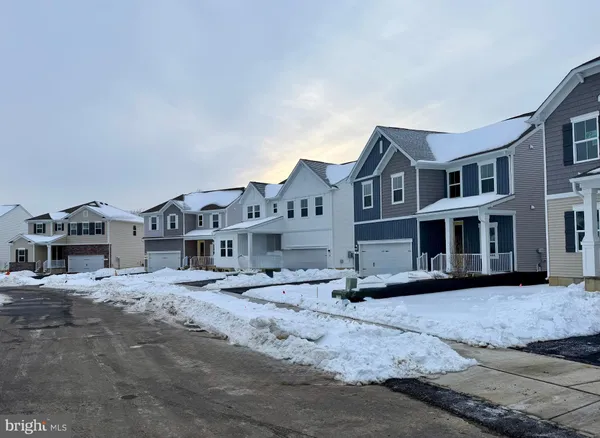 a view of residential houses with snow on the road