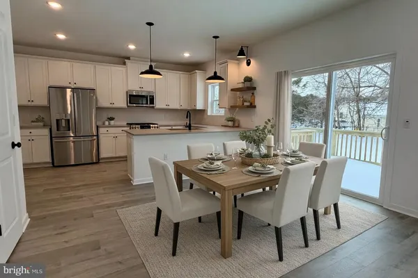 a view of a dining room with furniture a chandelier and wooden floor
