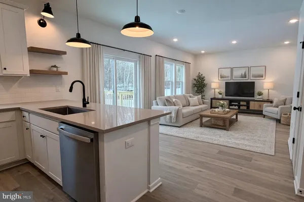 a kitchen with stainless steel appliances granite countertop a sink a stove and a wooden floors