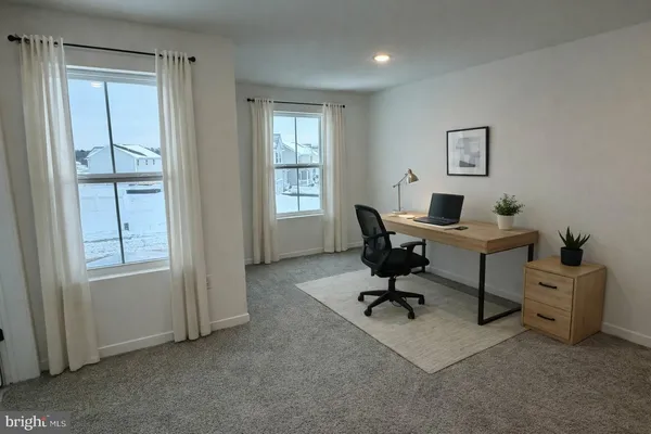 a view of a livingroom with workspace and a window