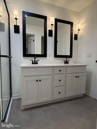 a bathroom with a double vanity sink and mirror