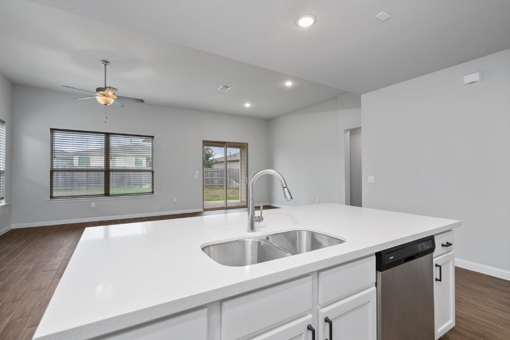 8301 Turnberry Lane Austin, TX 78744 - Photo 33 of 33 Kitchen with dark wood-type flooring, white cabinets, dishwasher, open floor plan, and recessed lighting