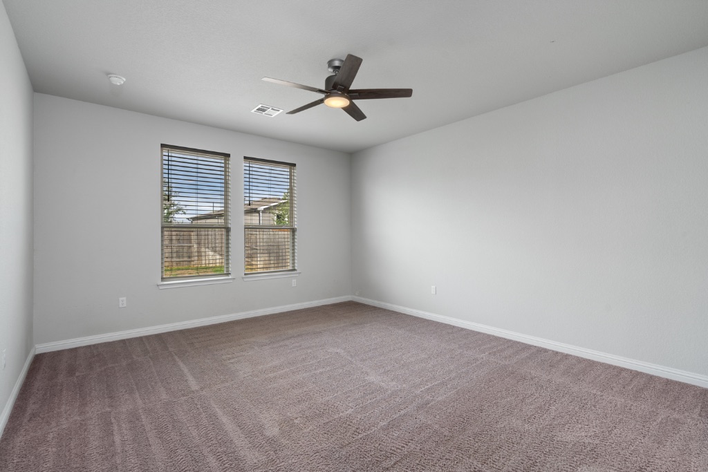 8301 Turnberry Lane Austin, TX 78744 - Photo 13 of 33 Carpeted empty room with baseboards and a ceiling fan