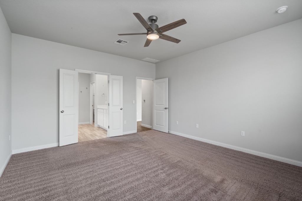 8301 Turnberry Lane Austin, TX 78744 - Photo 14 of 33 Unfurnished bedroom with carpet, ceiling fan, and ensuite bath