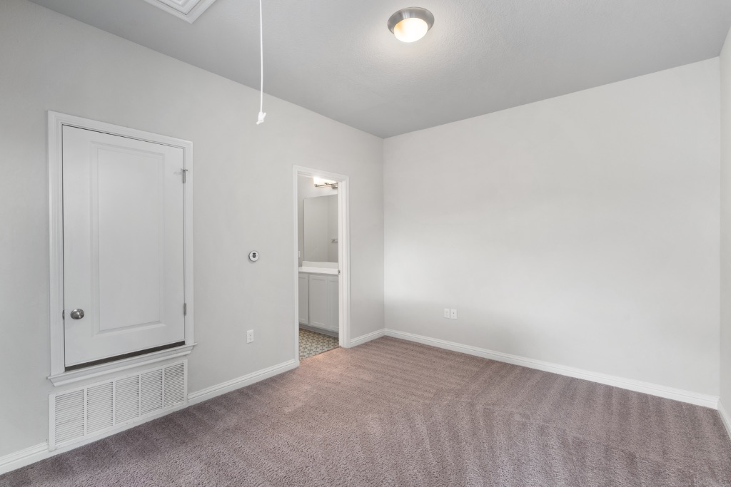 8301 Turnberry Lane Austin, TX 78744 - Photo 18 of 33 Unfurnished bedroom featuring attic access, carpet flooring, and ensuite bathroom
