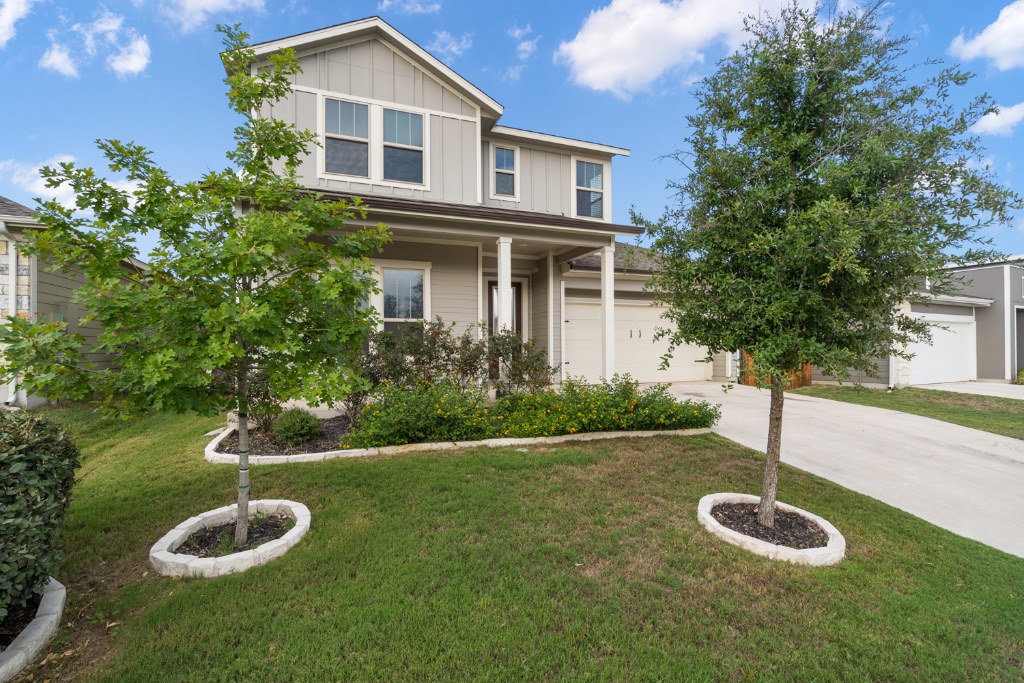 8301 Turnberry Lane Austin, TX 78744 - Photo 2 of 33 View of front of property with board and batten siding, a front lawn, a garage, and concrete driveway