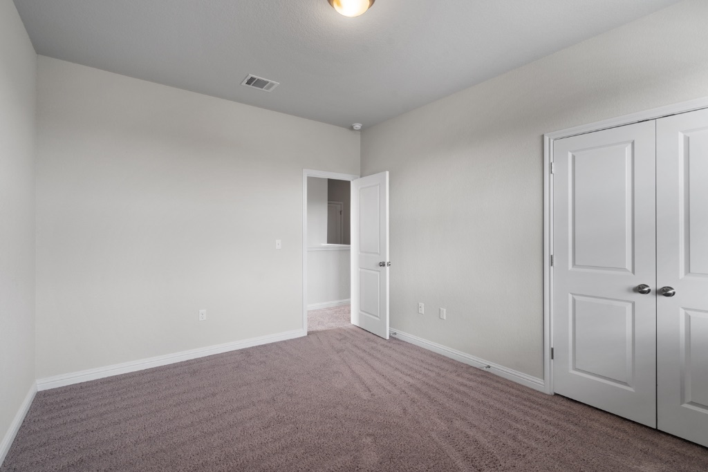 8301 Turnberry Lane Austin, TX 78744 - Photo 26 of 33 Unfurnished bedroom with carpet and a closet