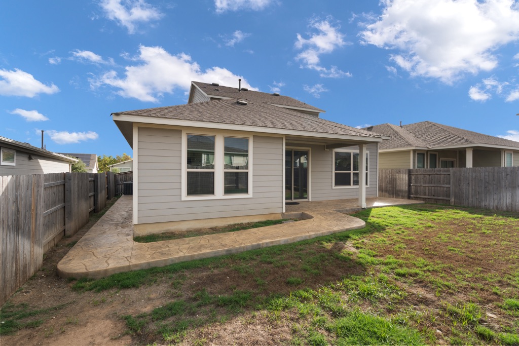 8301 Turnberry Lane Austin, TX 78744 - Photo 29 of 33 Back of house with a patio area, a fenced backyard, and roof with shingles