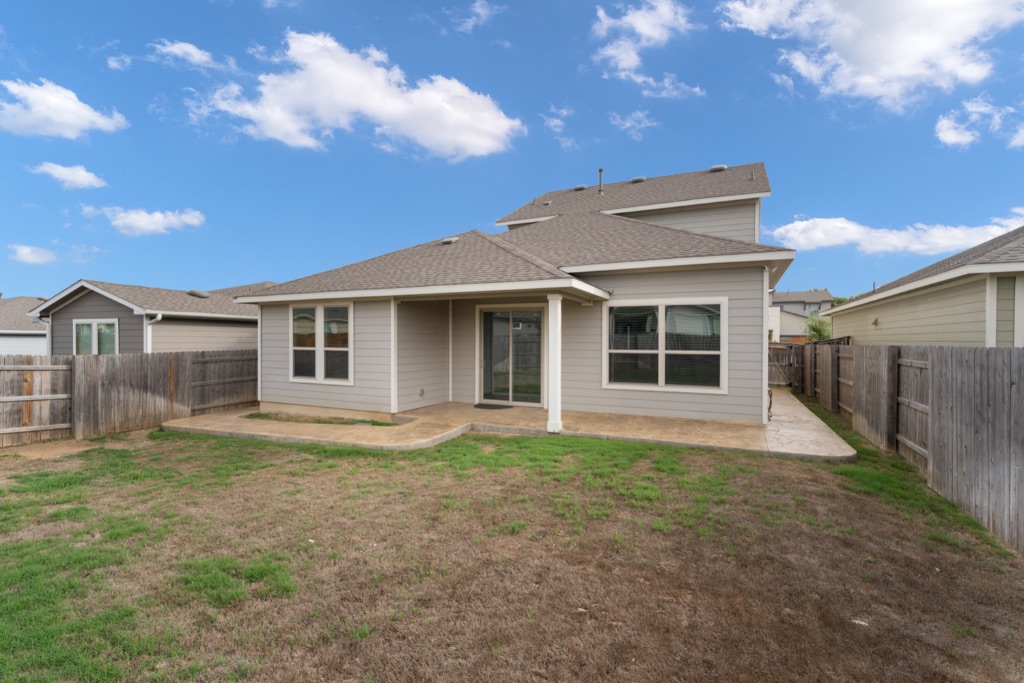 8301 Turnberry Lane Austin, TX 78744 - Photo 31 of 33 Rear view of house with a patio, a fenced backyard, and roof with shingles