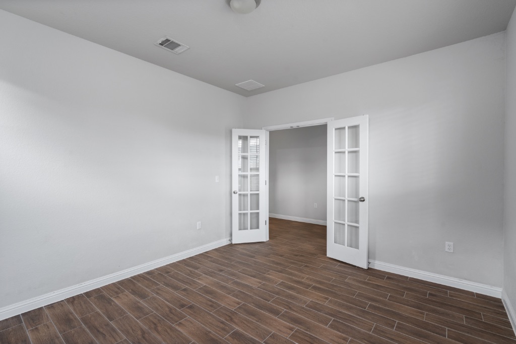 8301 Turnberry Lane Austin, TX 78744 - Photo 5 of 33 Unfurnished room featuring wood tiled floors and french doors