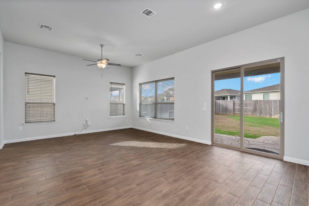 8301 Turnberry Lane Austin, TX 78744 - Photo 7 of 33 Unfurnished room with wood finish floors, a ceiling fan, and recessed lighting