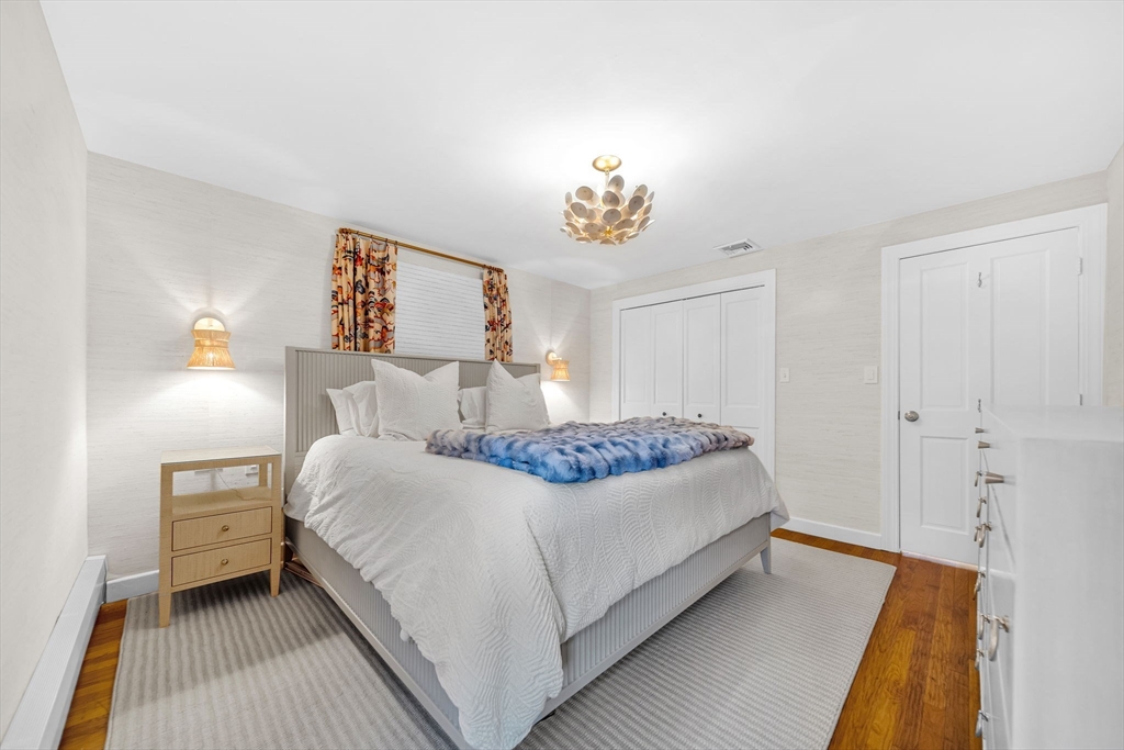 69 Donizetti Street Wellesley, MA 02482 - Photo 17 of 29 a bedroom with a bed and a chandelier