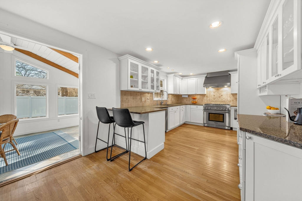 69 Donizetti Street Wellesley, MA 02482 - Photo 9 of 29 a kitchen with stainless steel appliances granite countertop a stove top oven a sink dishwasher and a refrigerator with wooden floor
