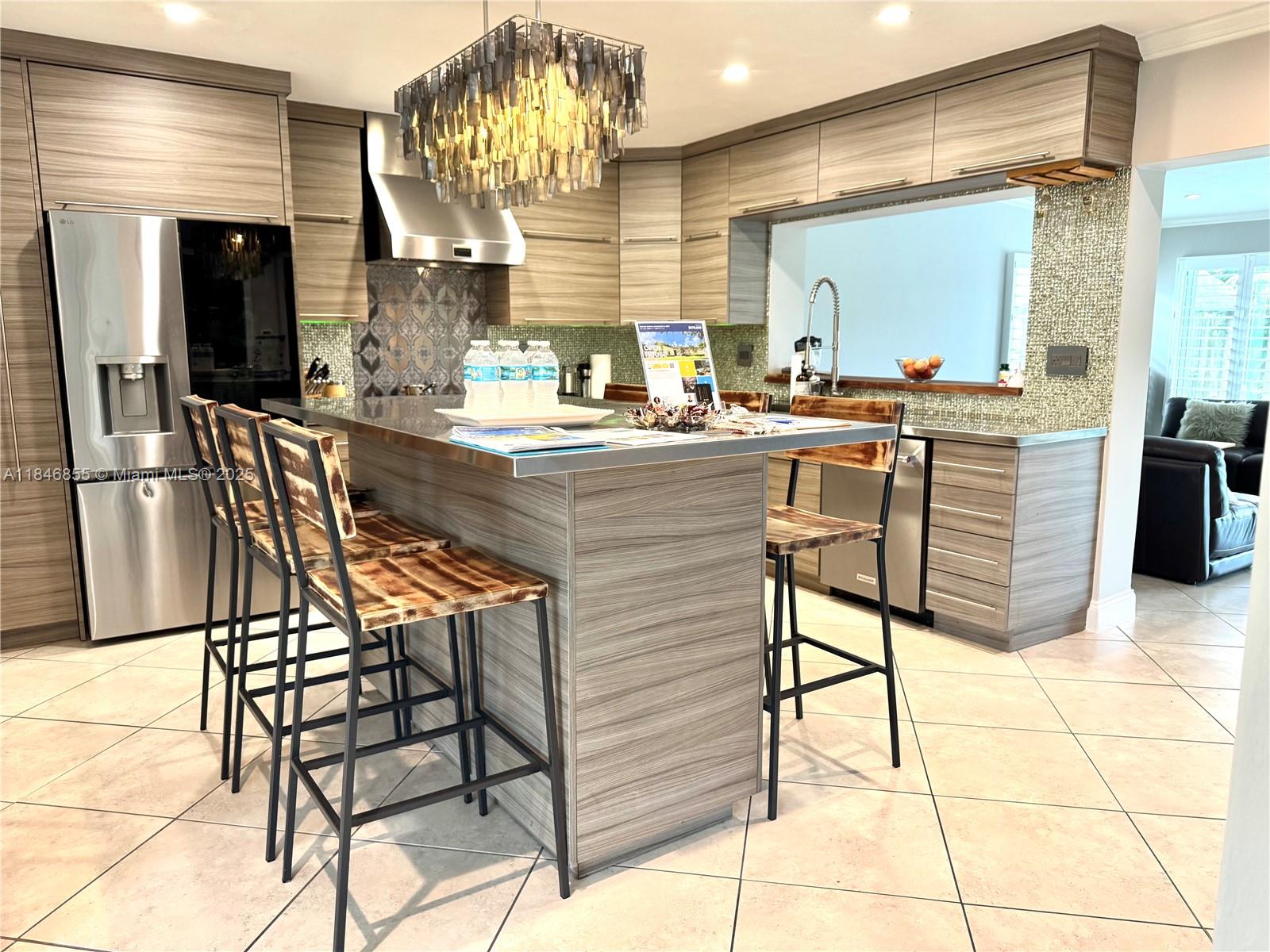 9385 Southwest 185th Street Cutler Bay, FL 33157 - Photo 14 of 27 a kitchen with stainless steel appliances kitchen island granite countertop dining table chair and a counter top space