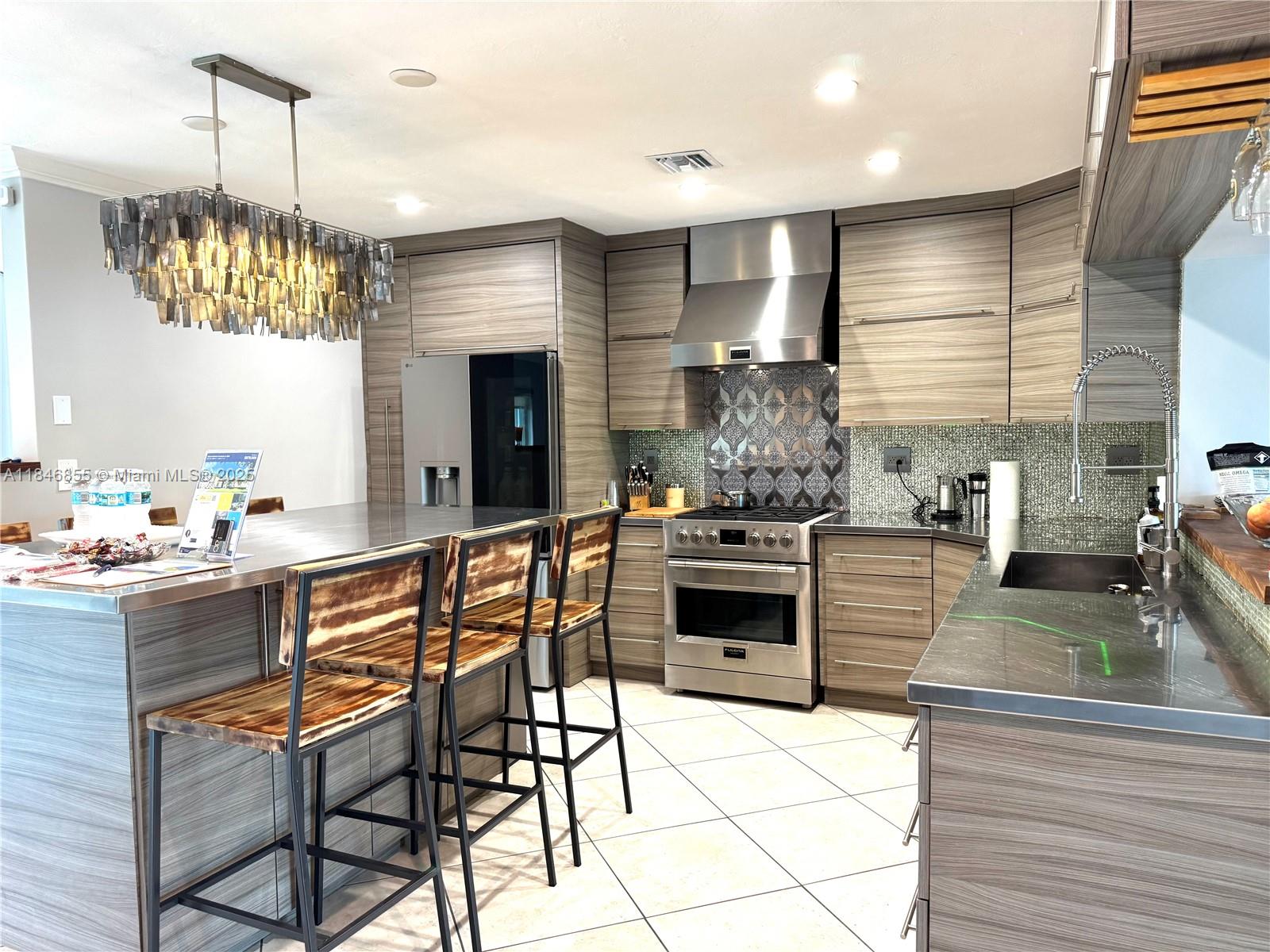 9385 Southwest 185th Street Cutler Bay, FL 33157 - Photo 15 of 27 a kitchen with stainless steel appliances kitchen island granite countertop a sink and cabinets