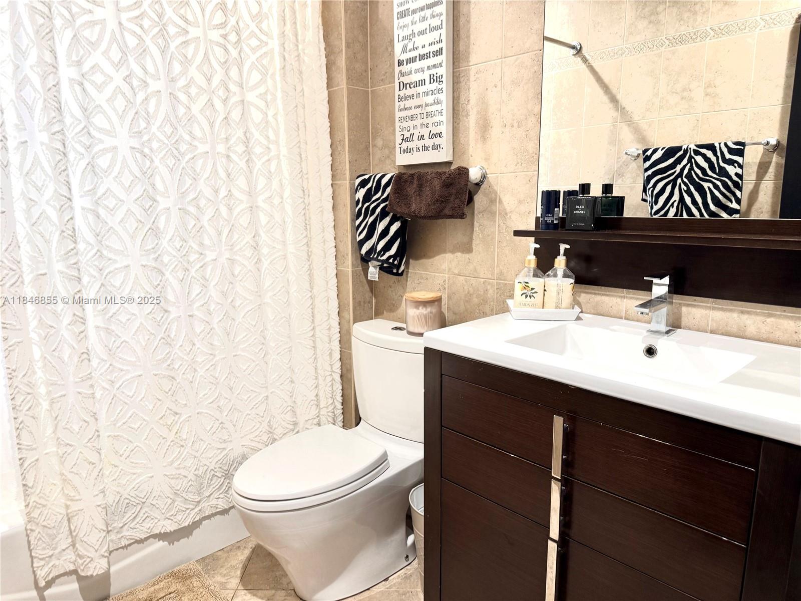 9385 Southwest 185th Street Cutler Bay, FL 33157 - Photo 18 of 27 a bathroom with a sink vanity mirror and toilet