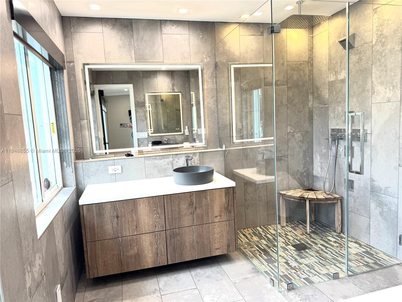 9385 Southwest 185th Street Cutler Bay, FL 33157 - Photo 20 of 27 a bathroom with a sink a mirror and a shower