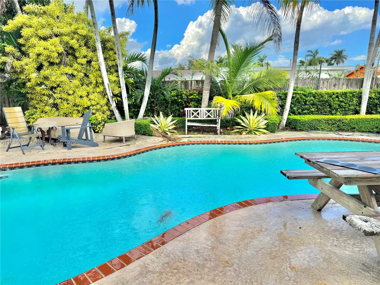 9385 Southwest 185th Street Cutler Bay, FL 33157 - Photo 5 of 27 a view of backyard with swimming pool and lawn chairs with plants