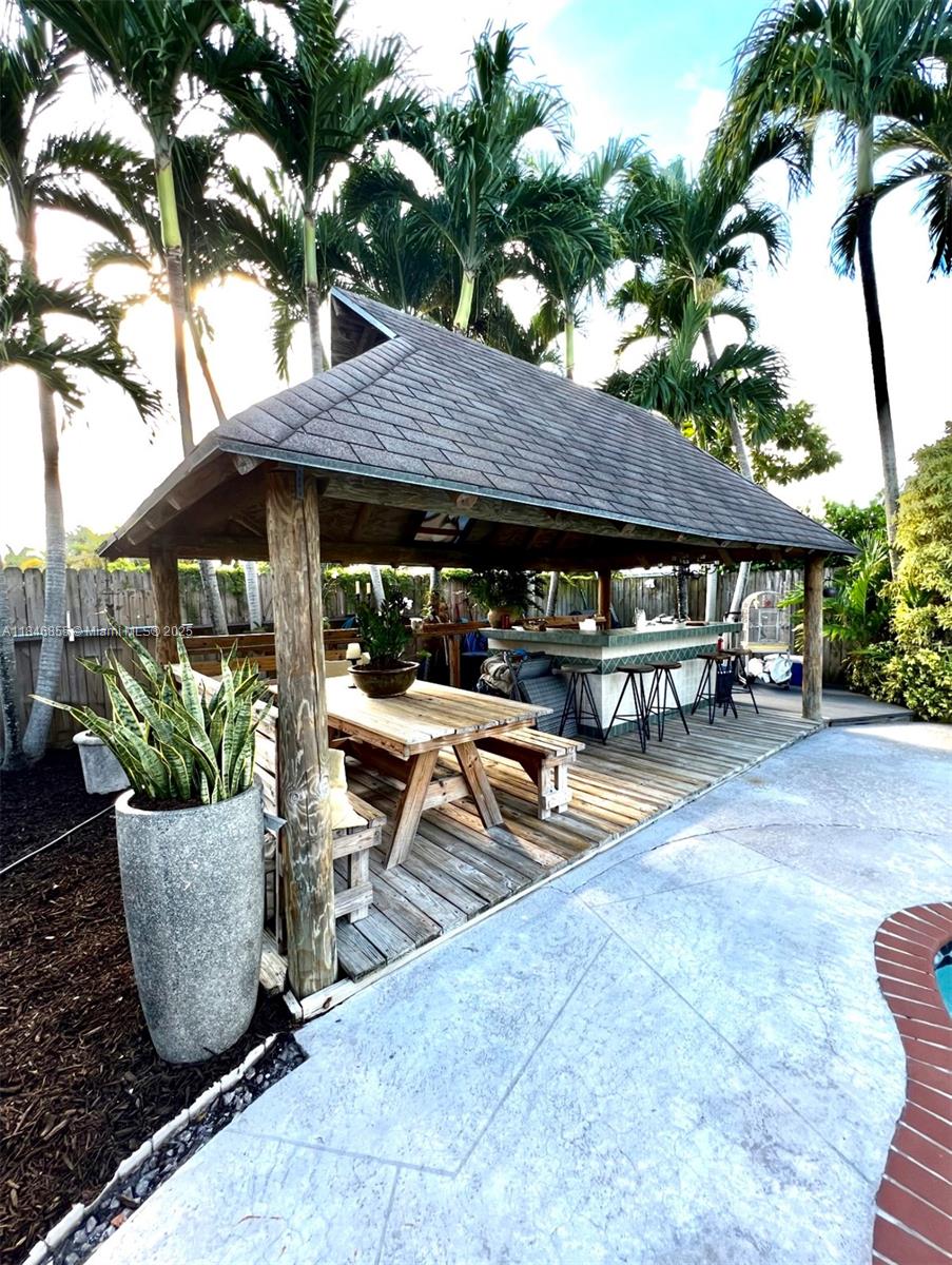 9385 Southwest 185th Street Cutler Bay, FL 33157 - Photo 9 of 27 a view of a patio with table and chairs under an umbrella