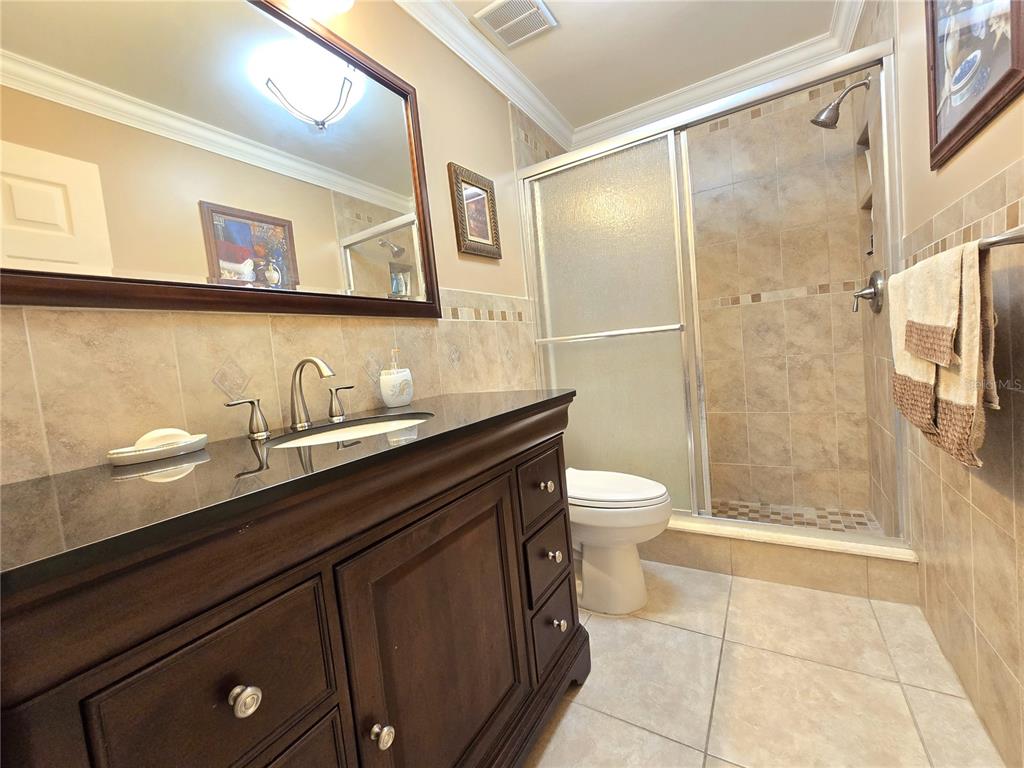 514 Brandon Avenue Clearwater, FL 33765 - Photo 17 of 67 a bathroom with a granite countertop sink a toilet a mirror and shower