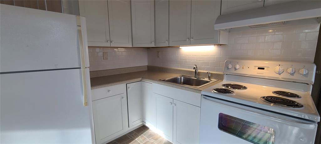 514 Brandon Avenue Clearwater, FL 33765 - Photo 24 of 67 a kitchen with white cabinets and white appliances