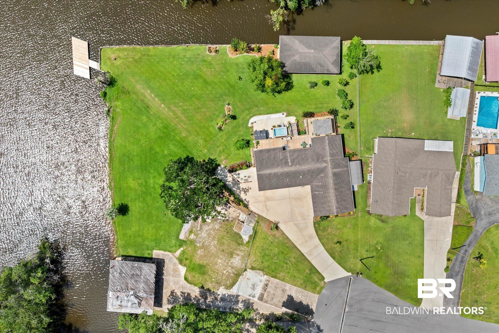 3801 Point Road Mobile, AL 36619 - Photo 42 of 55 Waterfront property featuring a private dock, expansive green lawn, mature trees, and a concrete driveway