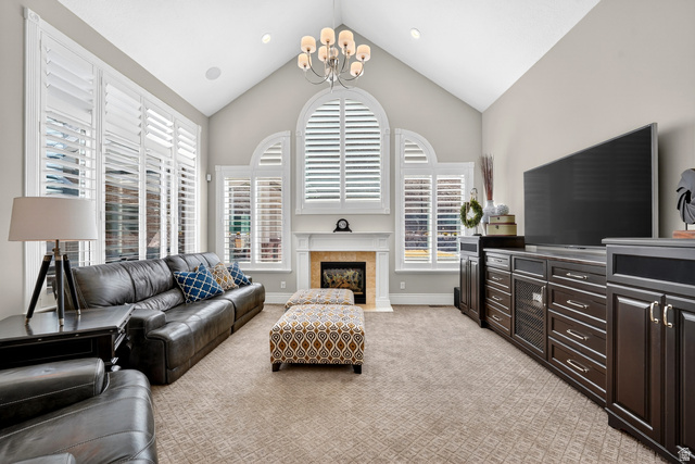 714 Draper Heights Way Draper, UT 84020 - Photo 38 of 88 Living area with a high ceiling, light colored carpet, healthy amount of natural light, and a chandelier