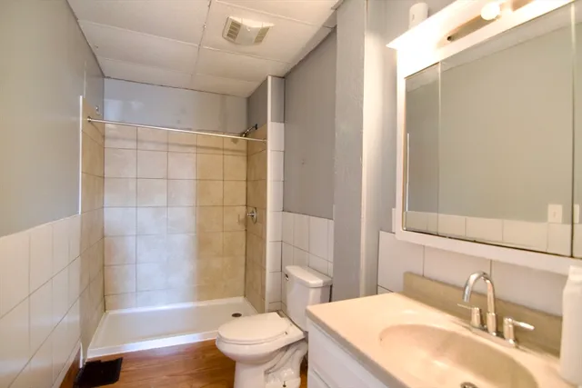 a bathroom with a granite countertop sink toilet and shower