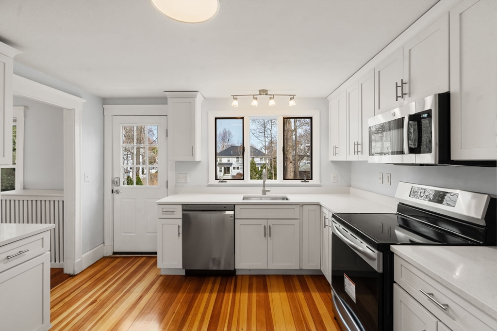 312 Edge Hill Road Milton, MA 02186 - Photo 10 of 34 a kitchen with stainless steel appliances a sink cabinets and wooden floor