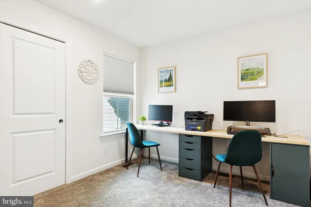 a view of a workspace with a computer on a desk and chair