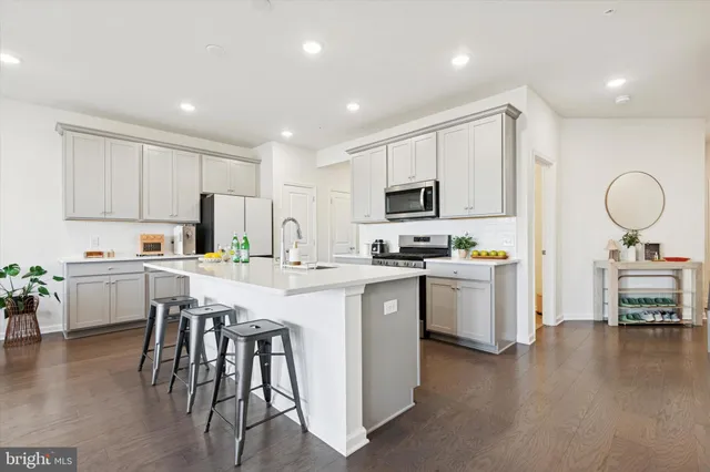 a kitchen with a sink white cabinets and stainless steel appliances