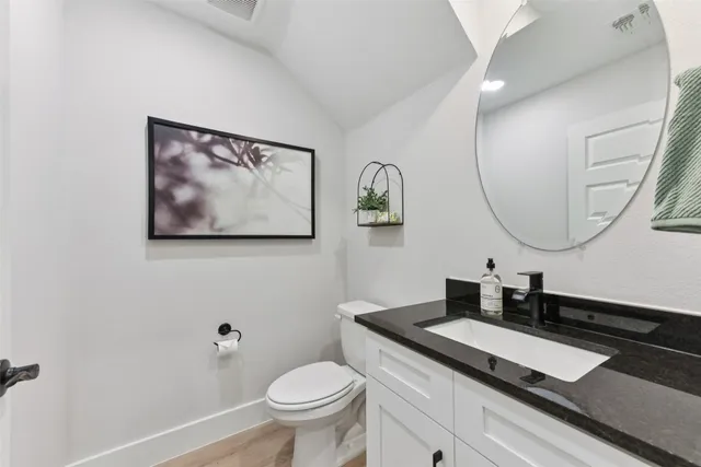 a kitchen that has a lot of white cabinets and stainless steel appliances
