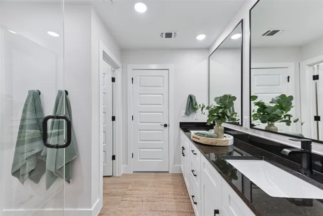 a bathroom with double vanity and a large mirror