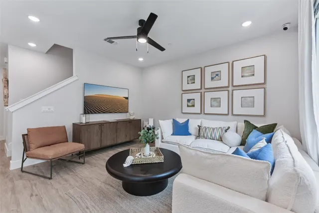 a living room with furniture and a wooden floor