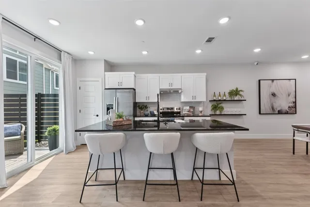 a kitchen with stainless steel appliances granite countertop a kitchen island a stove a table and chairs