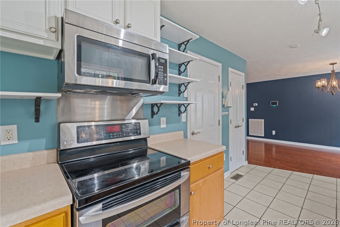 115 Shelby Street Spring Lake, NC 28390 - Photo 18 of 40 a kitchen with stainless steel appliances granite countertop a stove and a microwave
