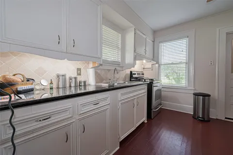 a kitchen with granite countertop white cabinets and white appliances