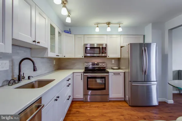 a kitchen with stainless steel appliances a refrigerator and a stove top oven