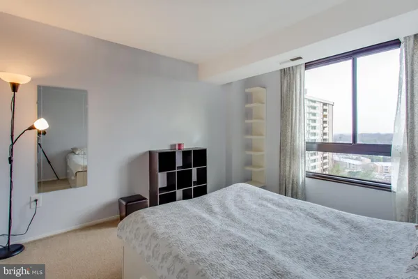 a spacious bedroom with a bed and large window