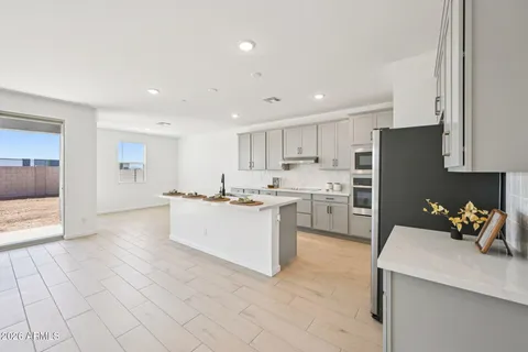a kitchen with stainless steel appliances a refrigerator stove and white cabinets