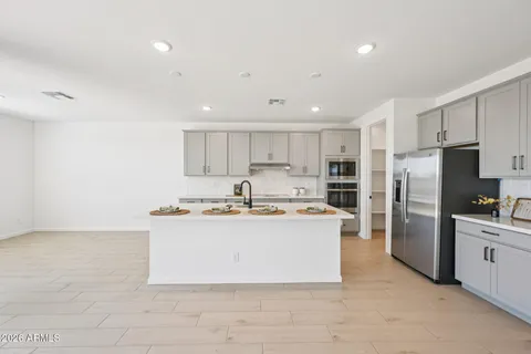 a kitchen that has a lot of cabinets in it and stainless steel appliances