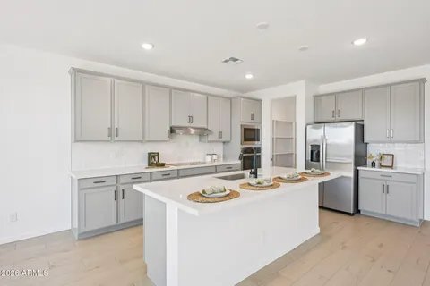 a kitchen with stainless steel appliances a sink stove top oven and cabinets